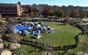 University of Missouri students circle tents on the Carnahan Quadrangle, locking arms to prevent media from entering the space following the resignation of President Timothy W. Wolfe on Monday, Nov. 9, 2015.