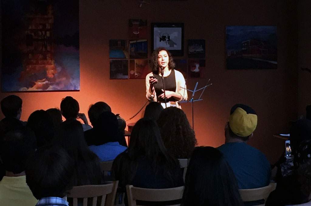Natalie Richardson, 19, a student at the University of Chicago in Illinois reads a new poem, “The Wedding,” at an open mic night inside High Ground Cafe in Iowa City on June 24, 2015. Richardson, an alumna of the National Student Poets Program, was visiting Between the Lines, an international youth writing program at the University of Iowa. Participants in BTL, the Iowa Young Writers’ Studio and Iowa Youth Writing Project participated in the open mic night as a way to get to know each other better and share their work. (Lynda Waddington/The Gazette)