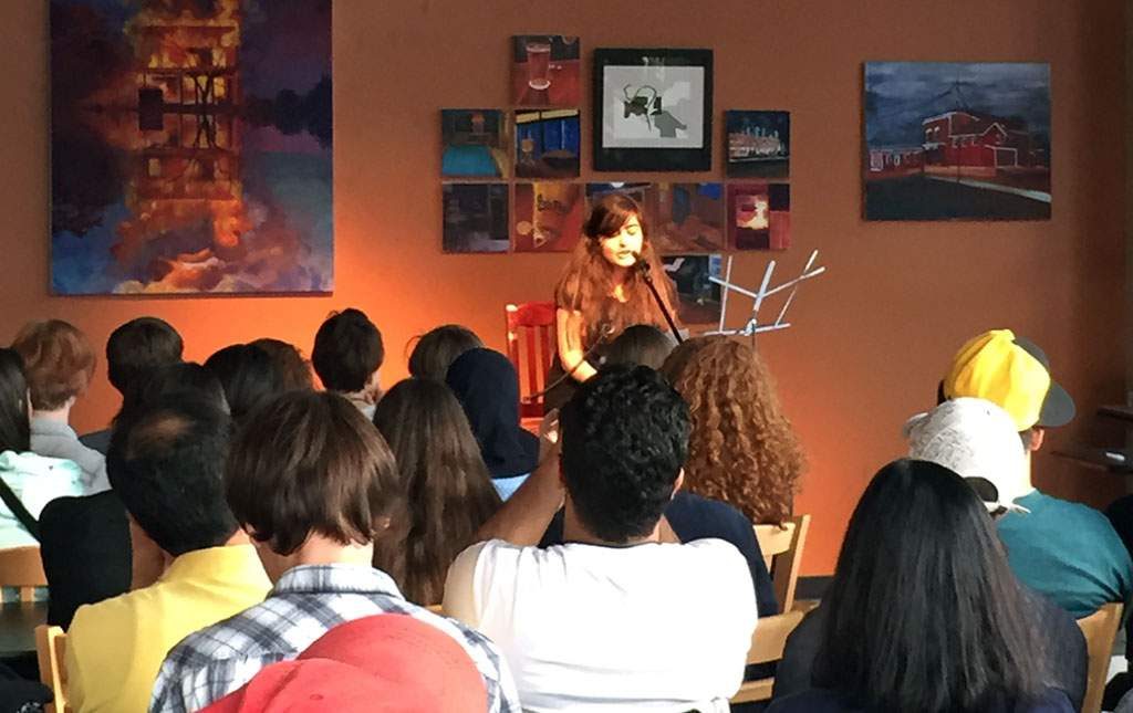 Jana Tabet, a 16-year-old from Lebanon, shares one of her original writings at an open mic night inside High Ground Cafe in Iowa City on June 24, 2015. The event provided teens in the Iowa Young Writers’ Studio, Iowa Youth Writing Project and Between the Lines (an international writing program) an opportunity to share their work and get to know each other better. (Lynda Waddington/The Gazette)