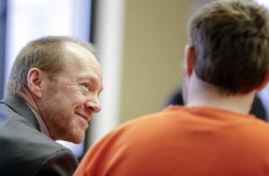 Linn County public defender David Grinde smiles as he gives encouragement to his client during a plea hearing at the Linn County Courthouse in Cedar Rapids, Iowa, in February 2016.