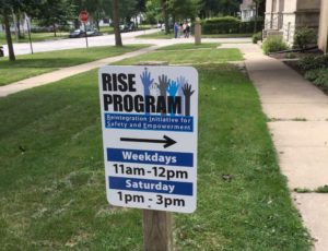 A sign outside the Mission of Hope directs the way to the Reintegration Initiative for Safety and Empowerment, or RISE, offices and lists the organization’s hours of operation.