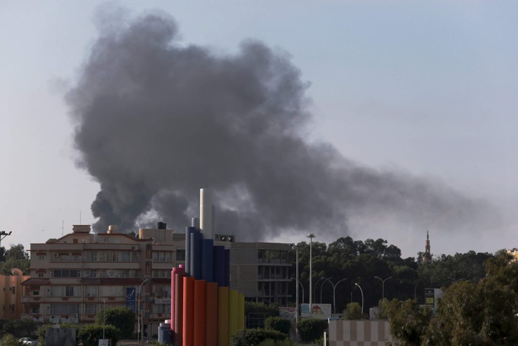 Black smoke billows above clashes between pro-government forces, who are backed by locals, and the Shura Council of Libyan Revolutionaries, an alliance of former anti-Gaddafi rebels, who have joined forces with the Islamist group Ansar al-Sharia, in Benghazi Nov. 26.