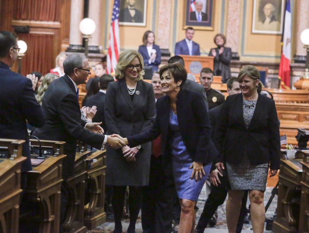 Iowa Gov. Kim Reynolds (center) greets legislators as she is lead out of the House chamber after delivering her Condition of the State Address to a joint assembly of the of state legislature at the Iowa State Capitol in Des Moines, Iowa, on Tuesday, Jan. 9, 2018.