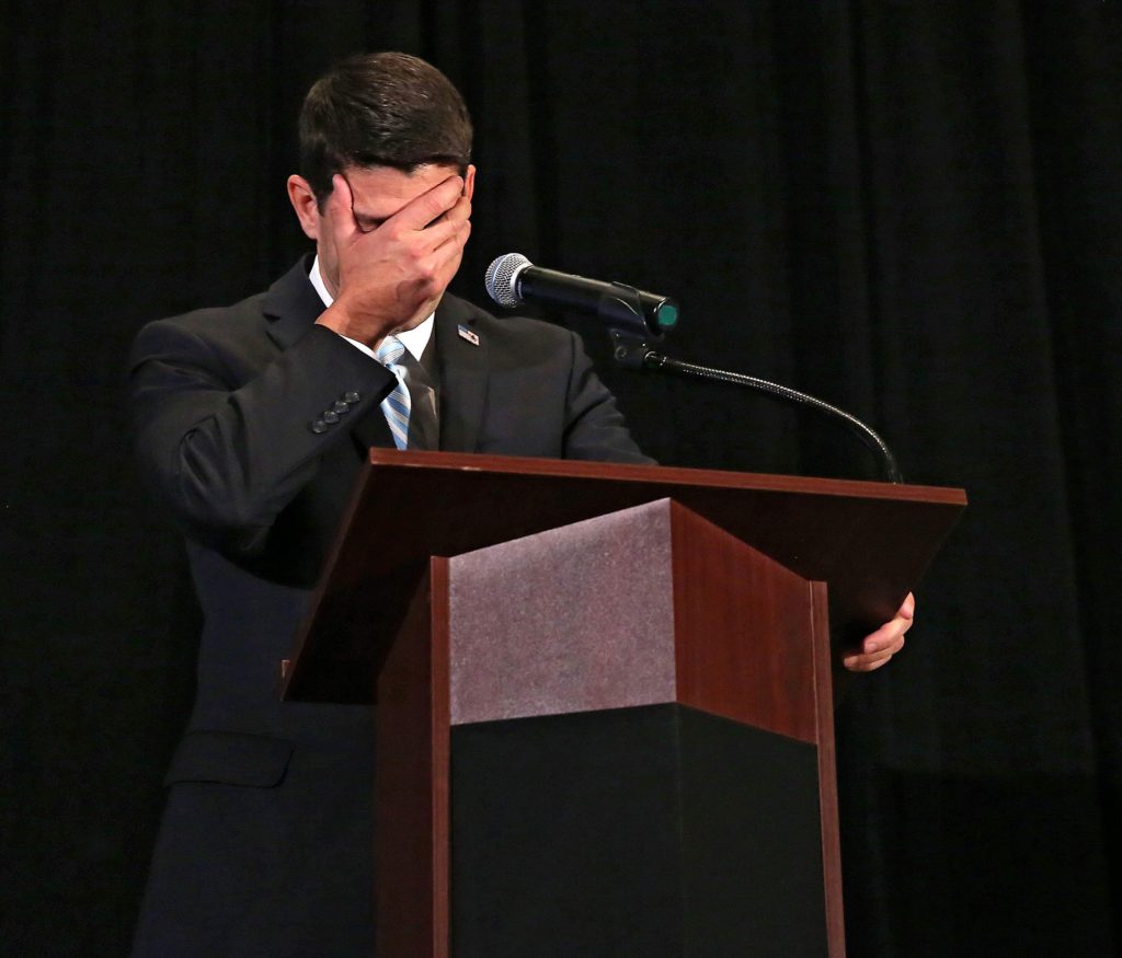 U.S. Rep. Paul Ryan, R-Wisc., covers his face as he tells a story during the Iowa GOP Lincoln Dinner at the DoubleTree by Hilton in Cedar Rapids on Aug. 11, 2014.