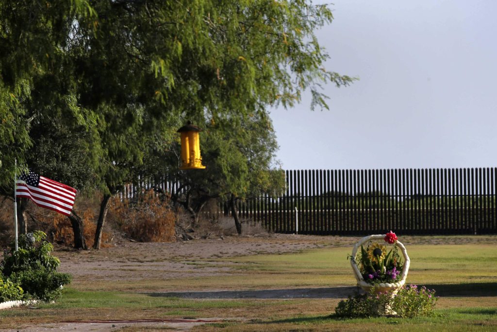 A U.S. flag blows in the wind in the backyard of a home facing the border fence at the United States-Mexico border outside of Brownsville, Texas, August 2014.